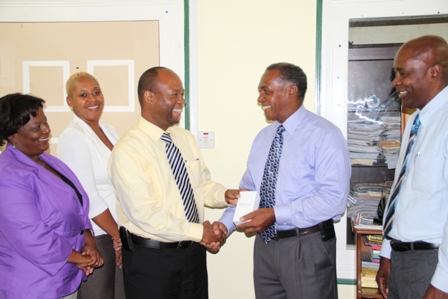 Digicel’s Country Manager for St. Kitts and Nevis Mr. Sean Latty presents Galaxy S3 handset to Premier of Nevis Hon. Vance Amory. The presentation was made on January 30th, 2013, at the Premier’s Bath Hotel office at Bath Plain. Mr. Latty is accompanied by (extreme L-R) Retail Sales and Distribution Manager Ms. Kaye M. Woods and St. Kitts and Nevis Corporate Sales Manager Ms. Jacinth Welsh. (L) Cabinet Secretary in the Nevis Island Administration Mr. Stedmond Tross looks on